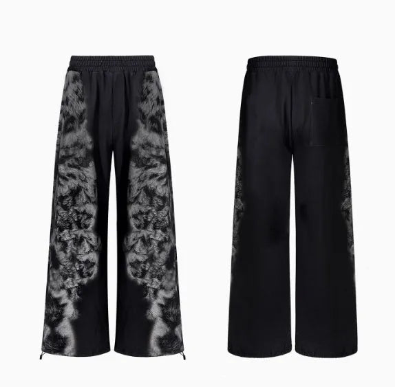 Woman wearing a loose-fit printed collage trouser and matching hoodie from a streetwear set.