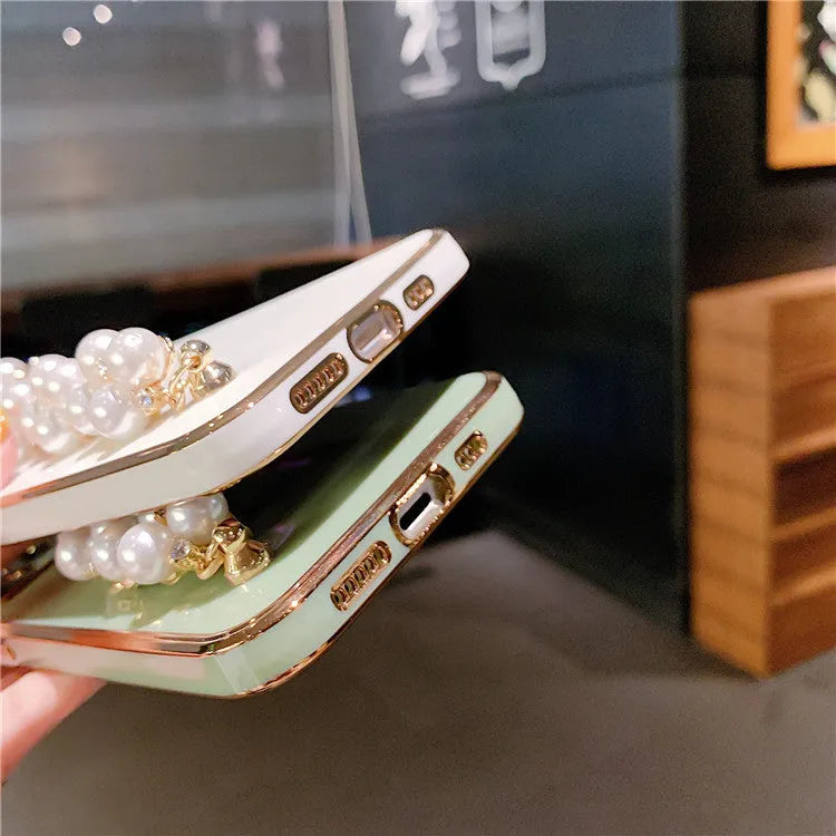 Soft TPU electroplated pearl wrist phone case for Apple iPhone in pink, showing back cover design.