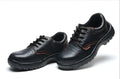 Black embossed cowhide safety shoes with steel toe cap and antiskid outsole on concrete floor