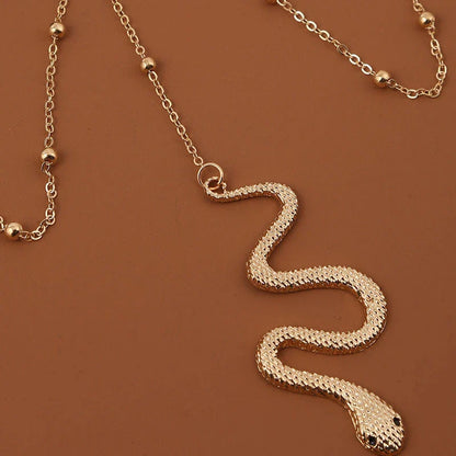 Chic bohemian gold chain leg jewelry with a captivating snake pendant, perfect for adding a touch of summer style to any outfit.