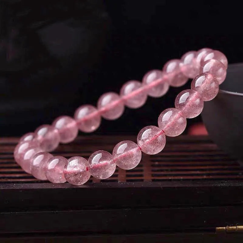 Women's strawberry quartz crystal bracelet showing polished natural stones in 6mm, 8mm or 10mm bead sizes