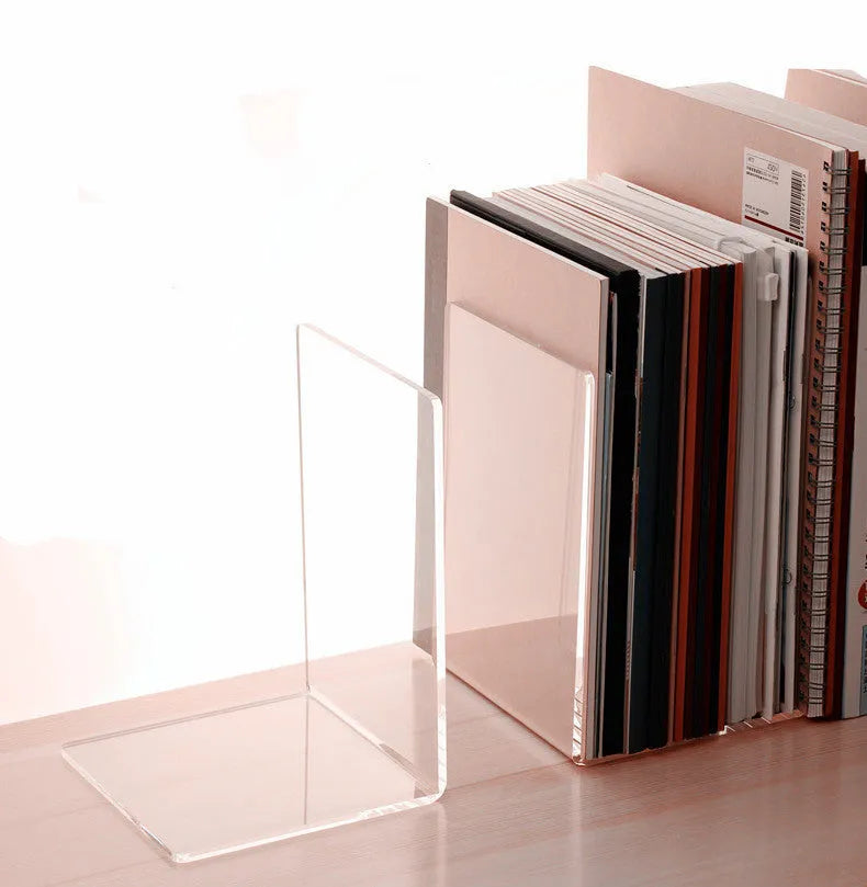 Transparent acrylic bookshelf holding a small stack of books on a wooden desk.
