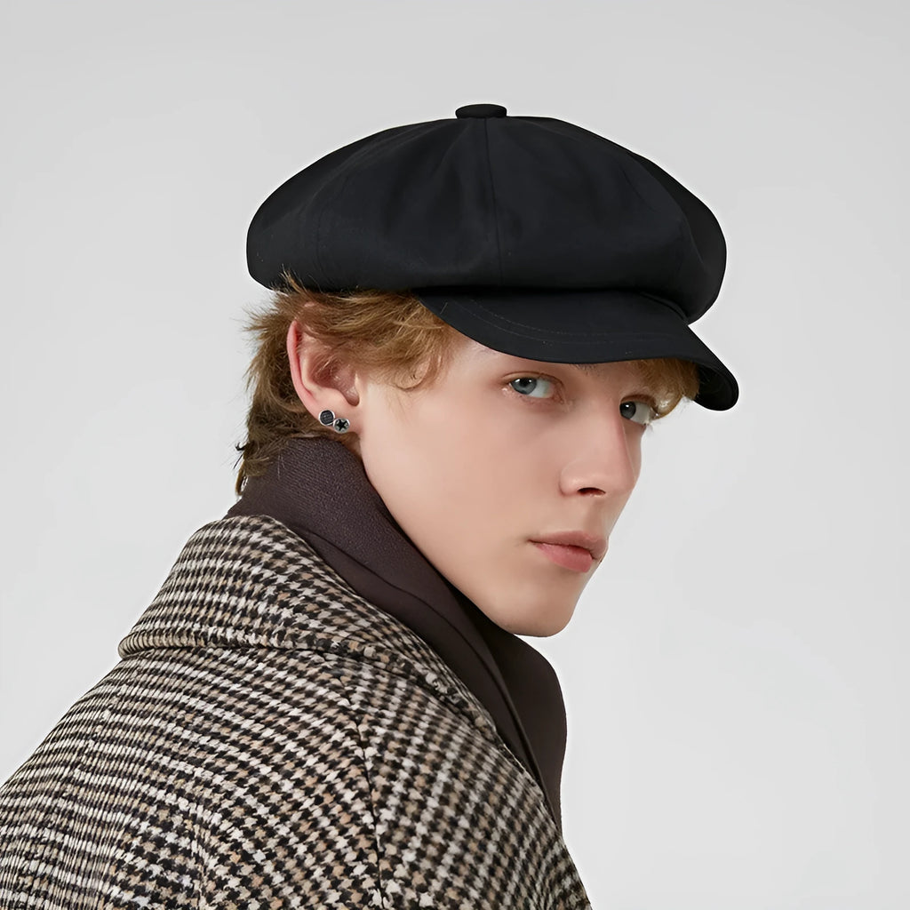 Cotton newsboy cap in black, octagonal dome crown, side view showing structure