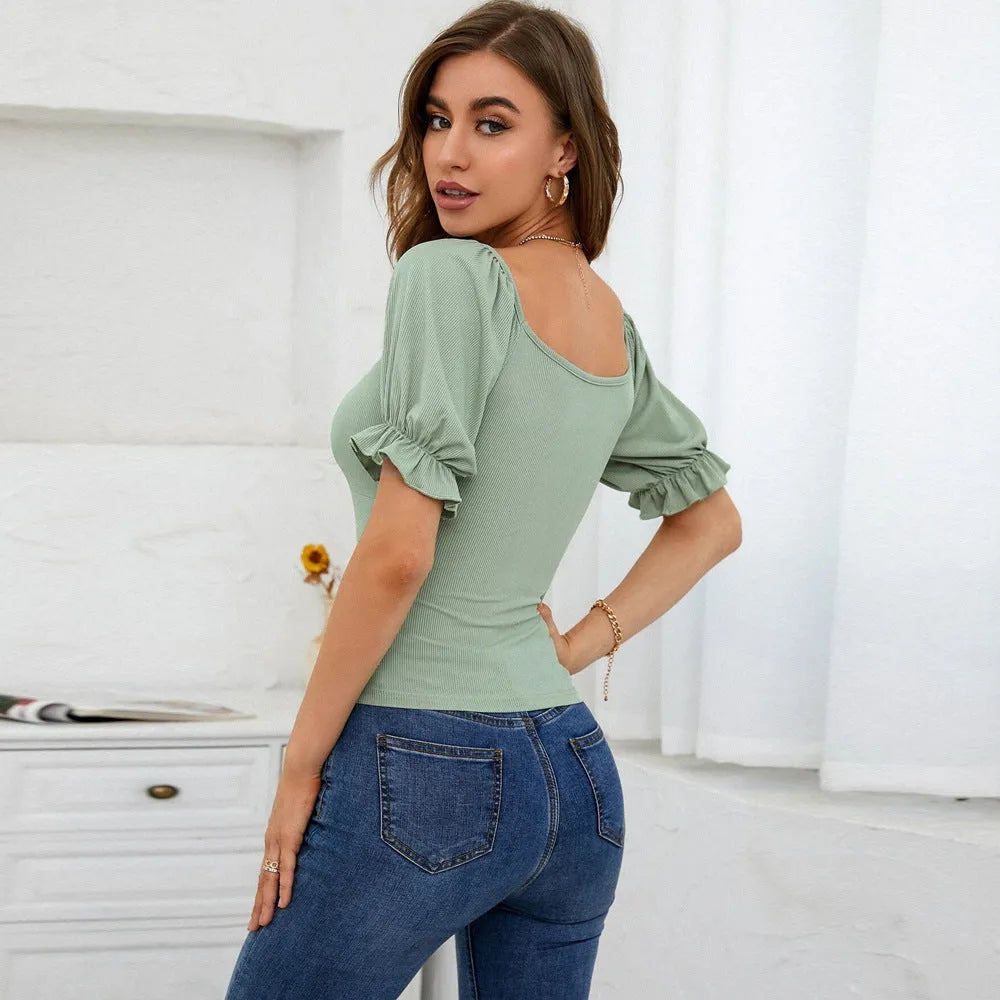 Women's light green slim-fit puff-sleeve knit top with shirred waist and ruffle trim on model