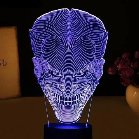 A 3D acrylic LED table lamp displaying colourful light patterns, with a remote control and USB cable.