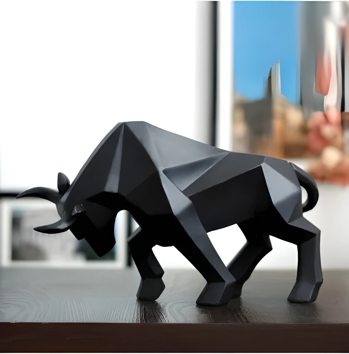 Modern geometric resin bull sculpture in black with abstract angular design on a neutral background
