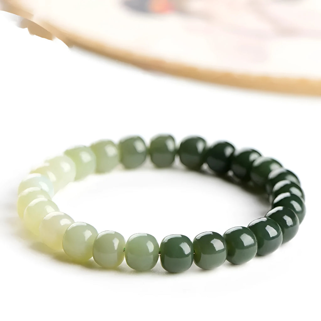 Natural Hetian jade bracelet with clear water gradient colour on wrist, showing polished beads.