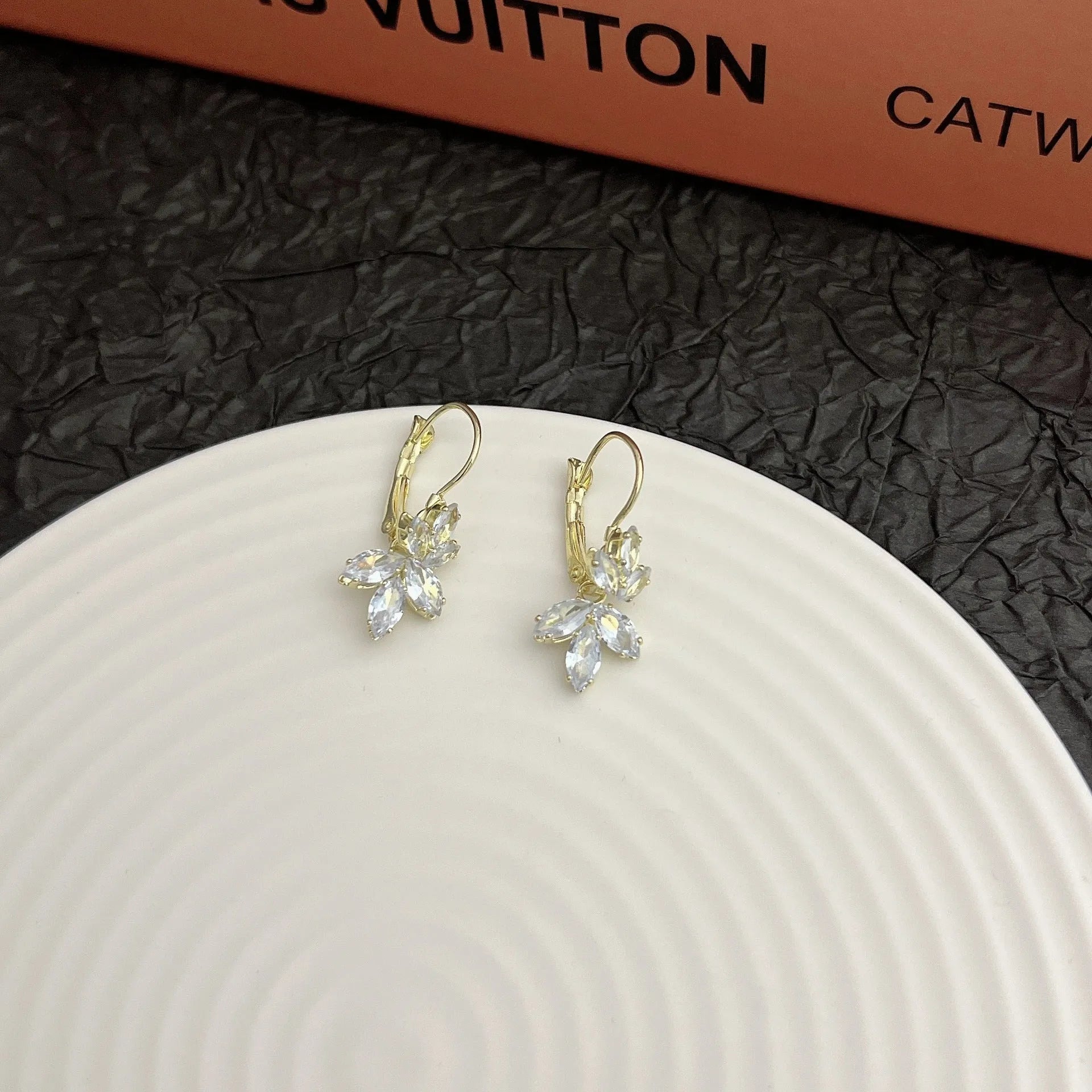 Women's platinum-colour leaf earrings with inlaid shiny zircon stones.