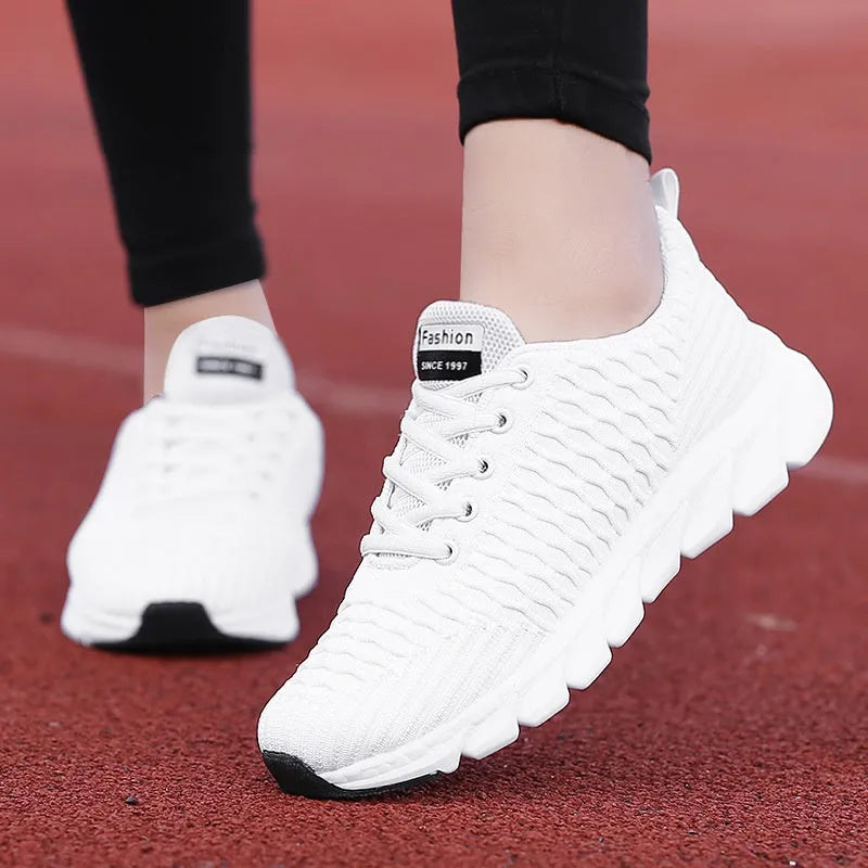 Women's running shoes in black with a fly weave upper and durable outsole.