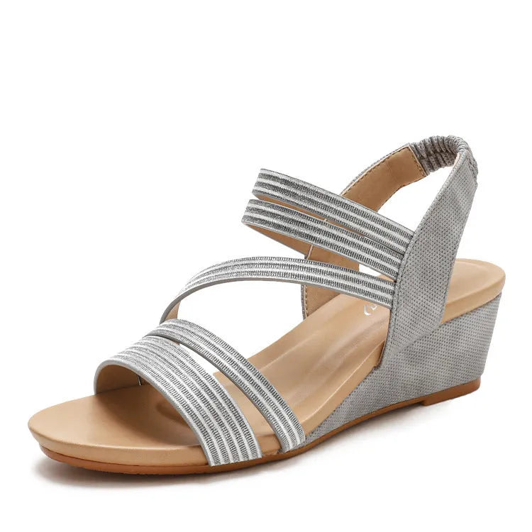 Gold women's platform sandals with a medium heel on a grey background.