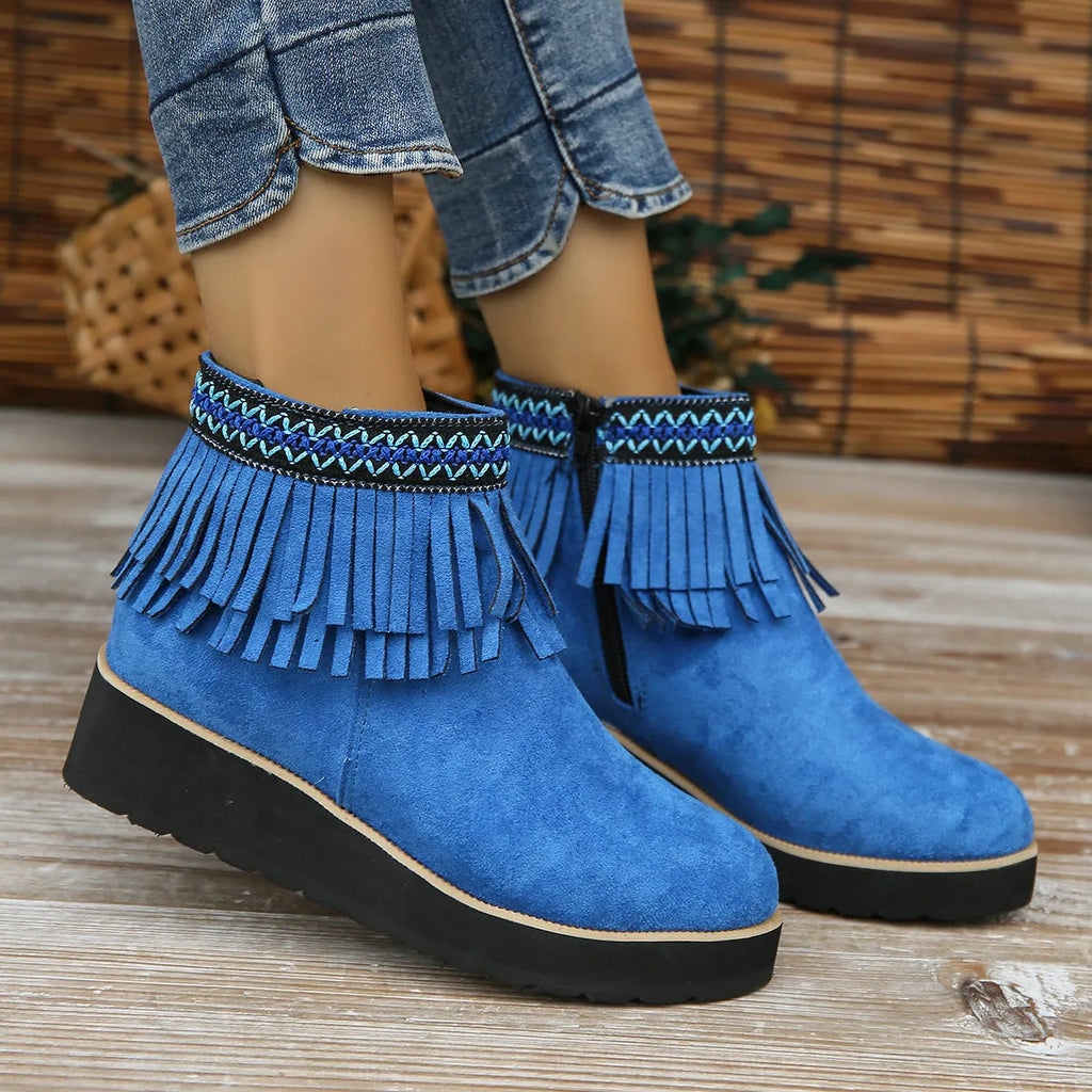 Women's black suede thick sole wedge ankle boots with side zip and tassel detail.
