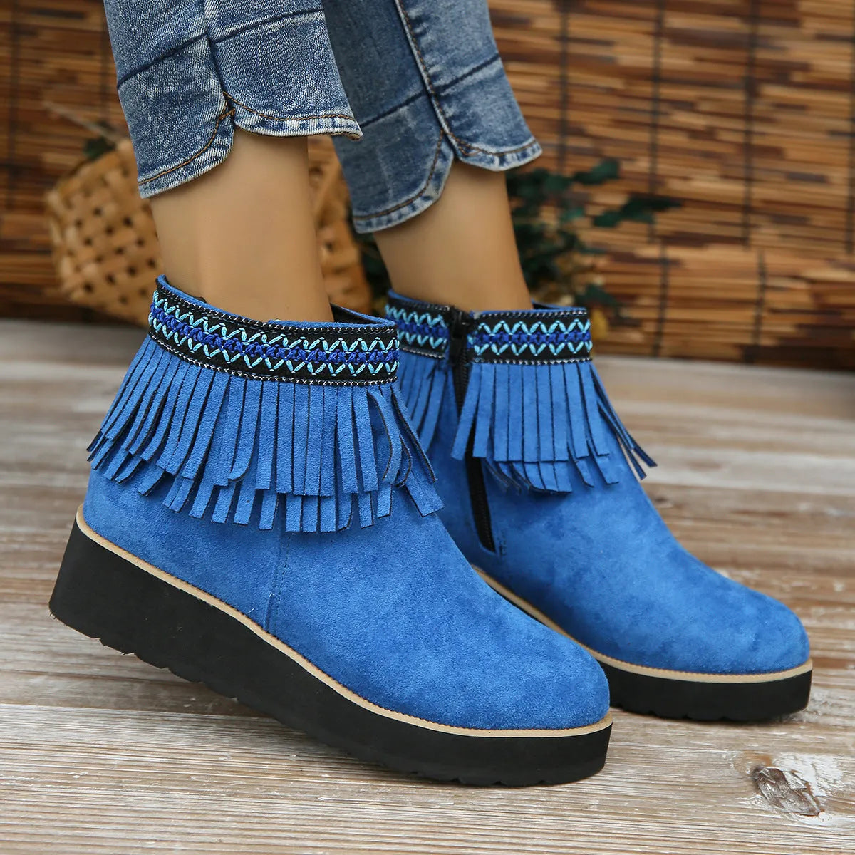 Women's black suede thick sole wedge ankle boots with side zip and tassel detail.