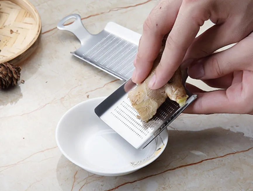 Silver 304 stainless steel garlic press with ergonomic ABS handle on a kitchen counter