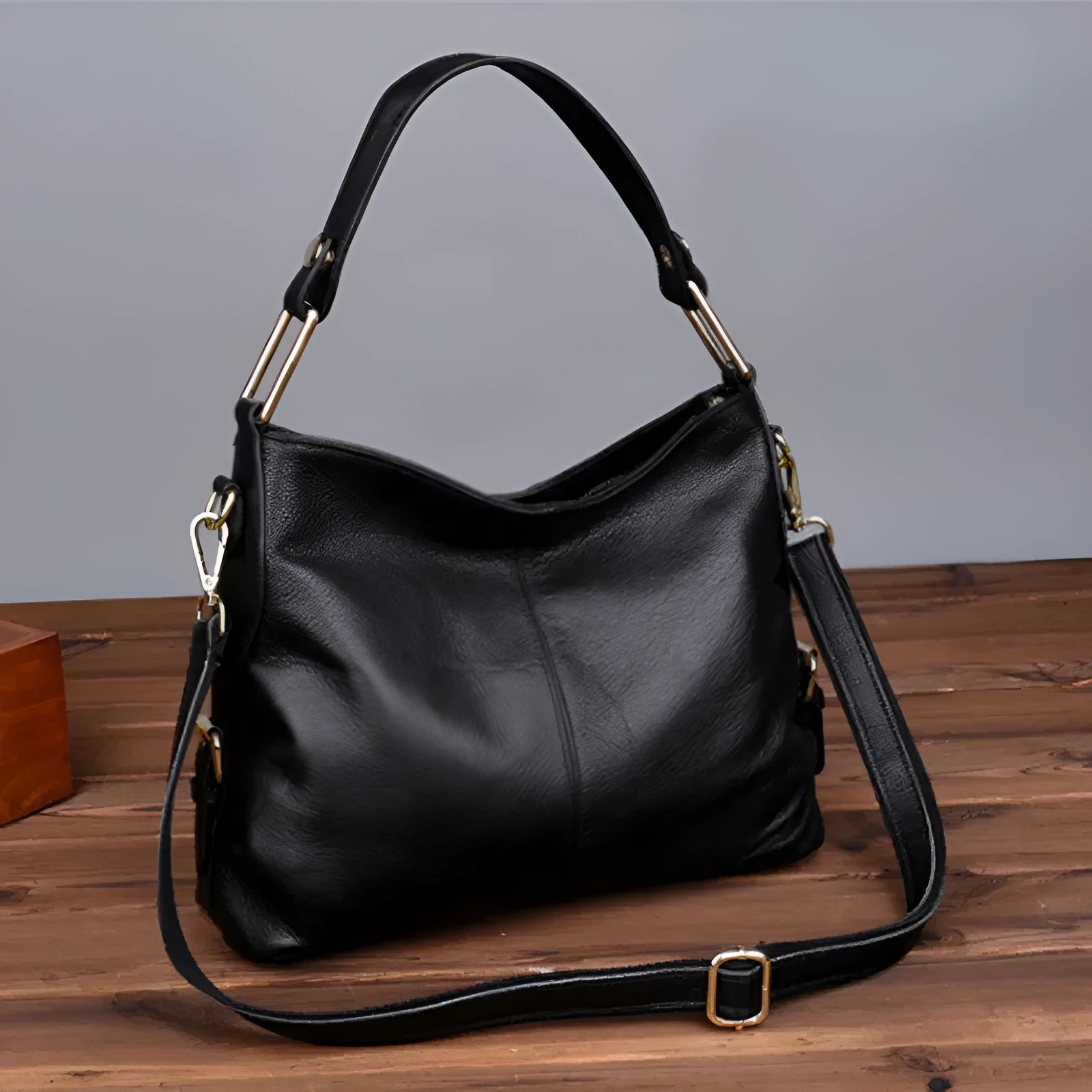 Genuine leather vertical square crossbody bag in black with multiple internal organiser pockets.