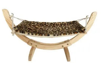 Cat hammock wooden bed with beige removable cushion on a radiator, providing a cosy perch for cats.