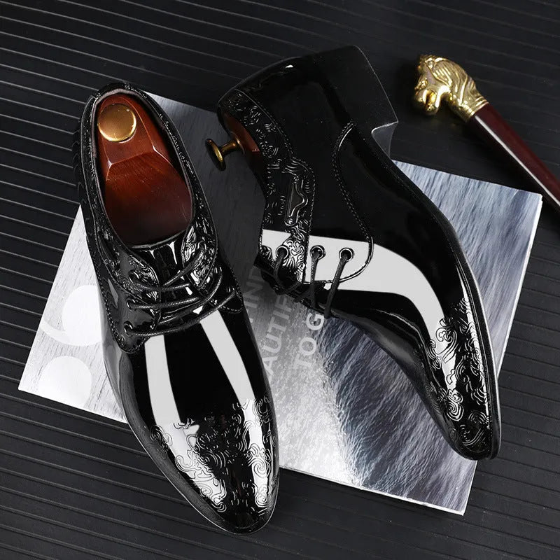Glossy black men's formal shoes with pointed toe, low top, and carved detail on microfiber leather upper