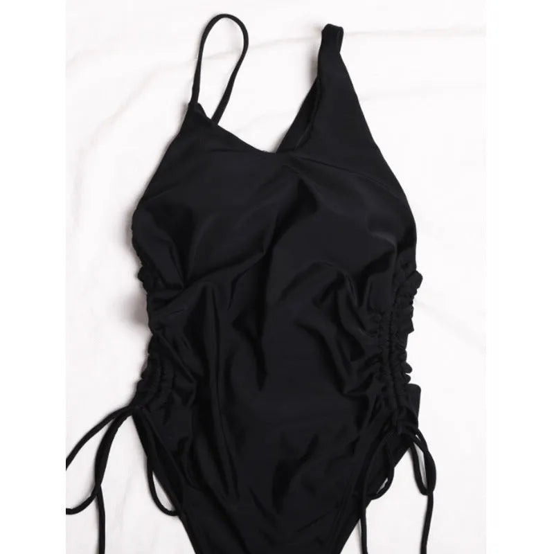 Black tight-fitting women's dress with sloping shoulder design and lacing detail