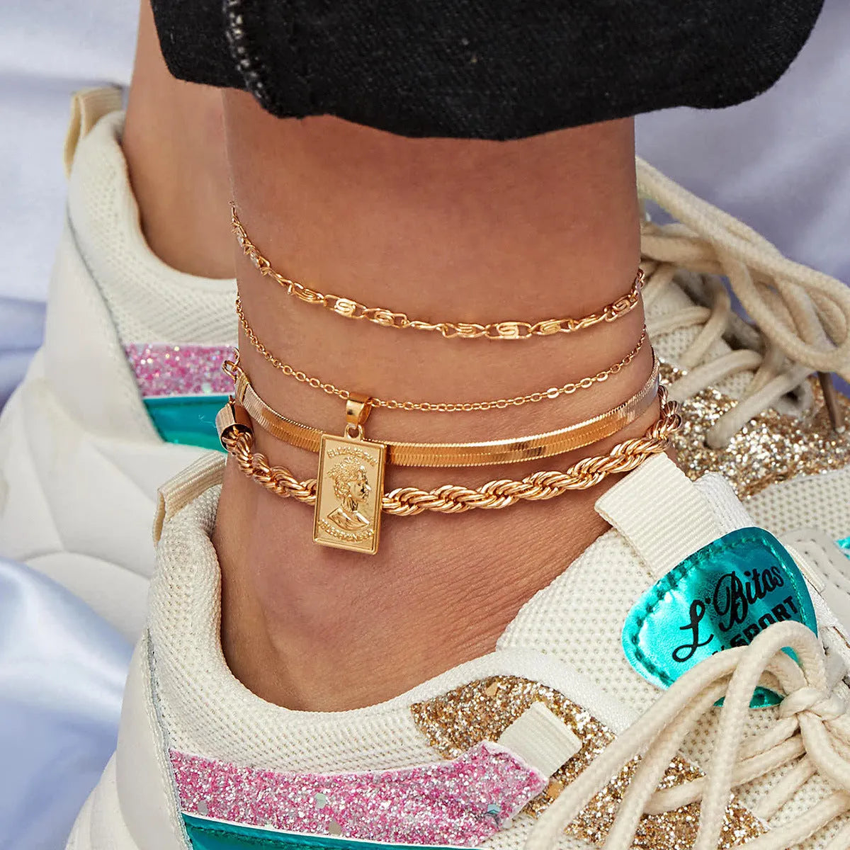 Golden geometric alloy electroplated anklet on white background