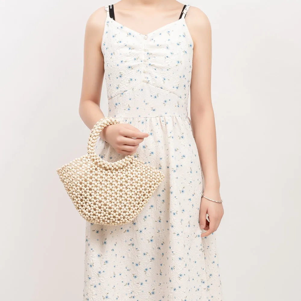 Maple wood woven dumpling-shaped handbag with wooden bead decoration, shown in milky white.