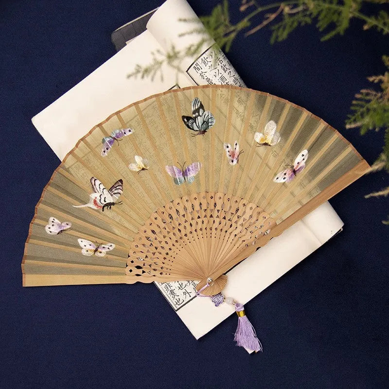 Bamboo folding fan with silk embroidery showing traditional Chinese patterns