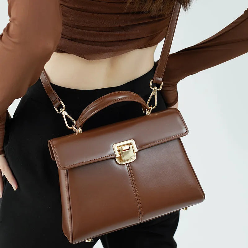 Black genuine leather women's shoulder bag with vachette clasp and long strap.