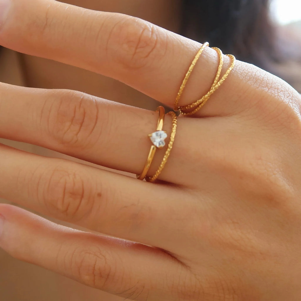 Women's golden electroplated stainless steel ring showing both love heart and oval shape variations