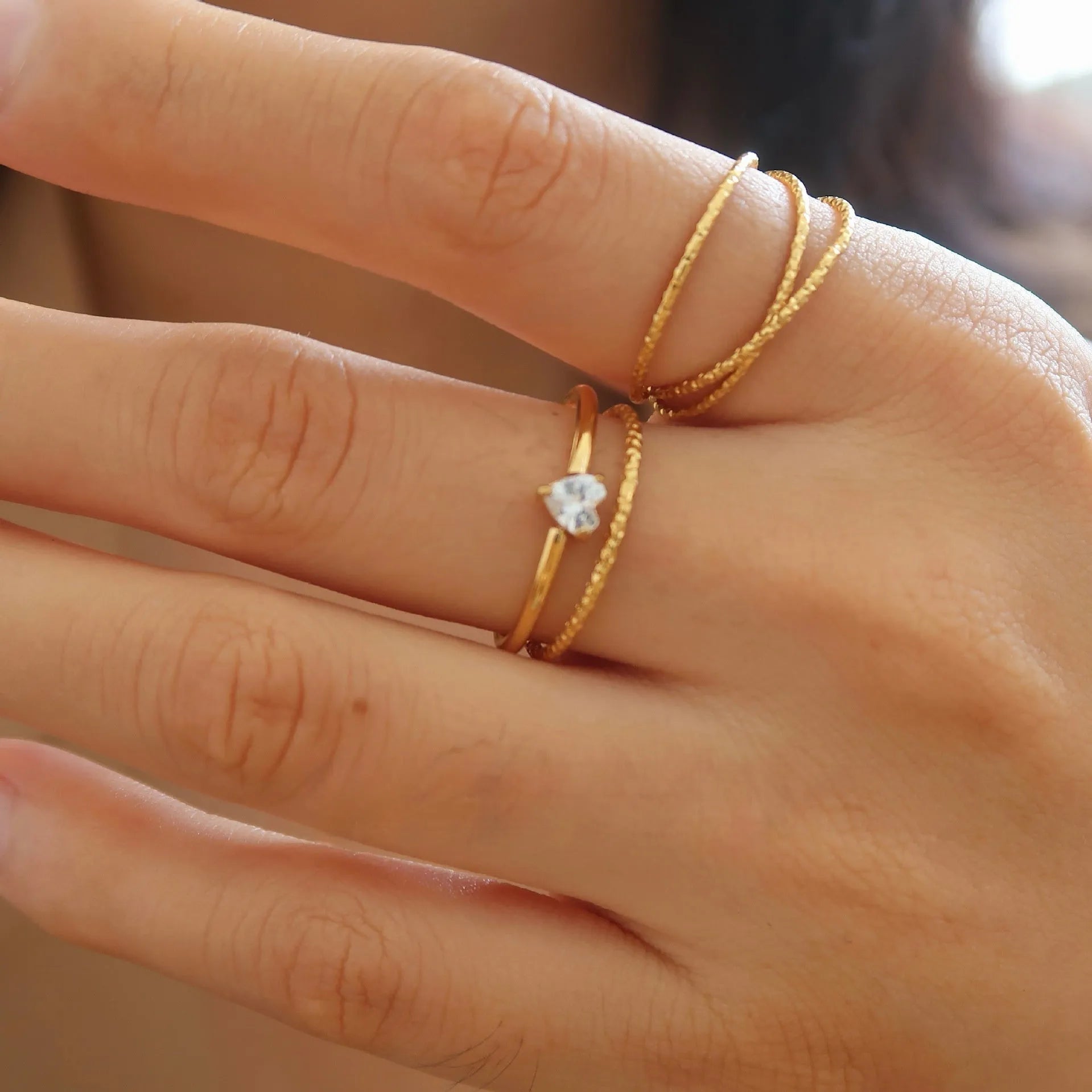 Women's golden electroplated stainless steel ring showing both love heart and oval shape variations