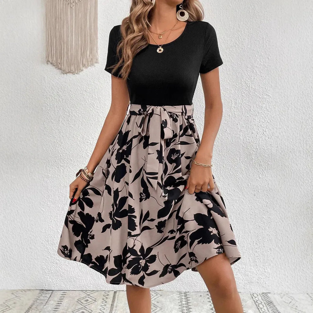 A khaki-coloured A-line women's dress with a floral print, showing regular sleeves and shoulder strap details.