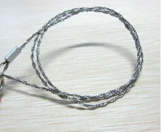 Stainless steel survival wire saw with pull rings, showing coiled 55 cm blade.