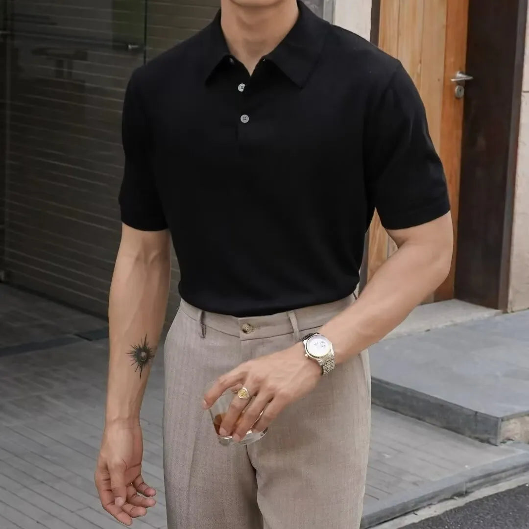 Men's black polo shirt with knitted collar and short sleeves laid flat.