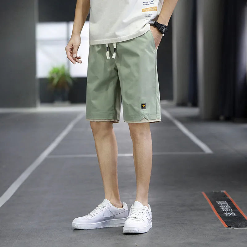 Casual straight-leg loose shorts in green polyester fabric on a neutral background.