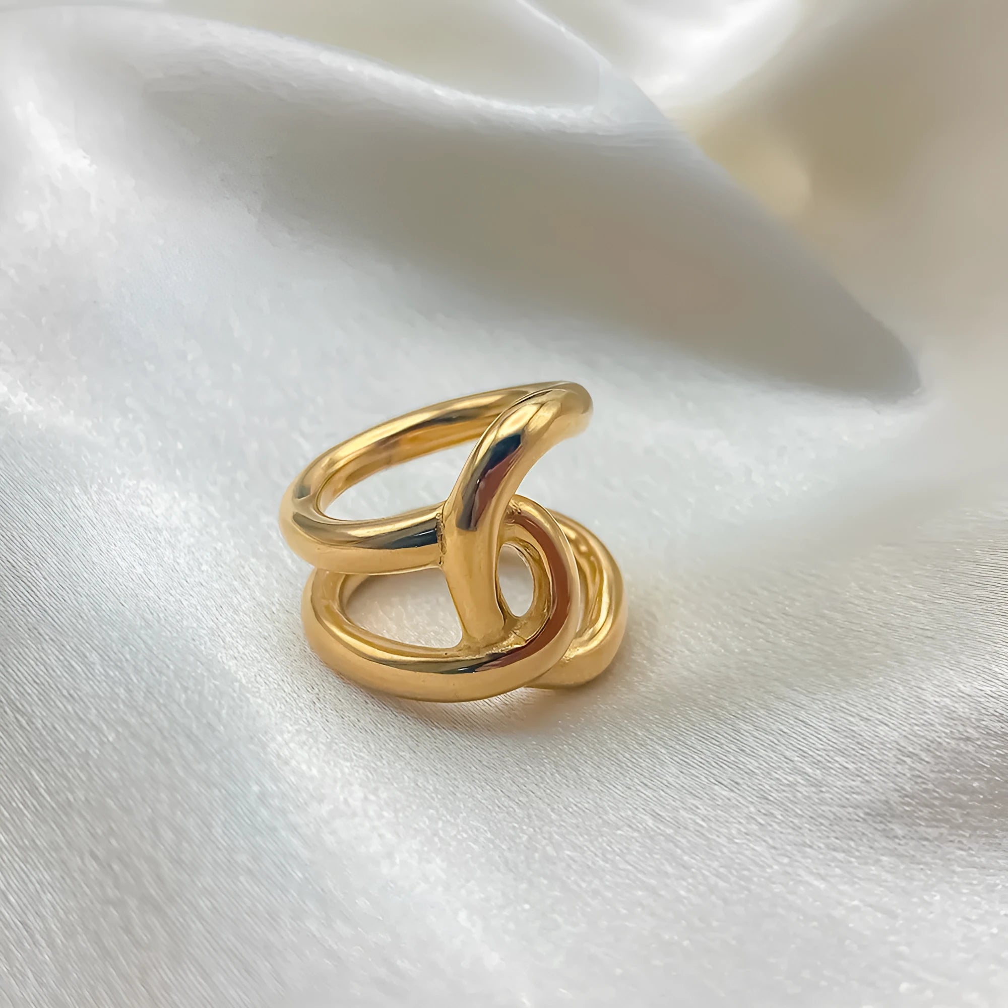 A stainless steel adjustable ring with a knotted detail on a U-shaped geometric band.