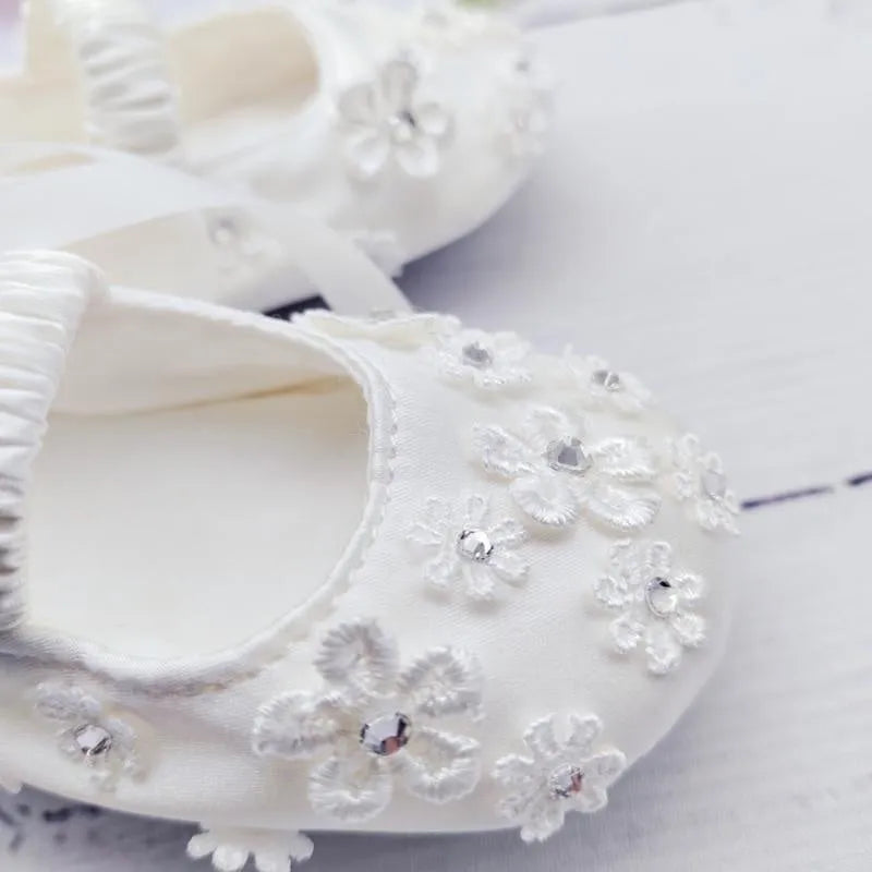 White baby soft bottom cloth princess shoes with rhinestone detail on a white background