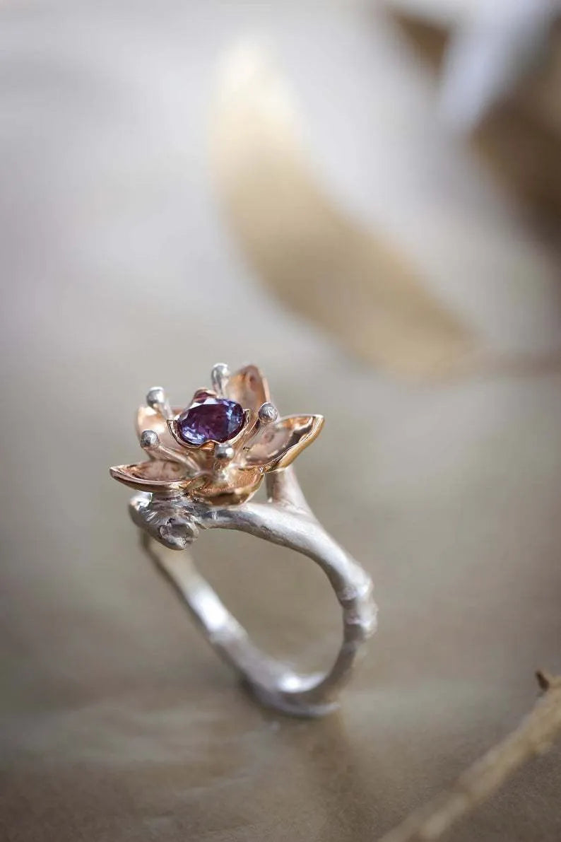 Silver two-tone floral pattern geometric alloy fashion ring for women on a grey background.