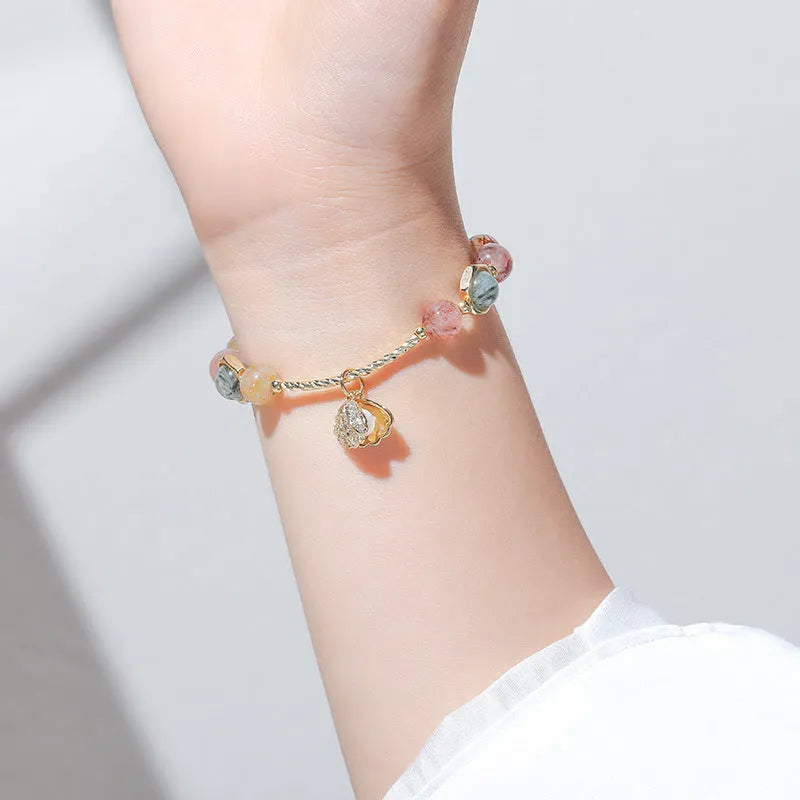 A women's crystal bracelet with colourful hair crystal shells and a red sealant flower shell on an electroplated band.