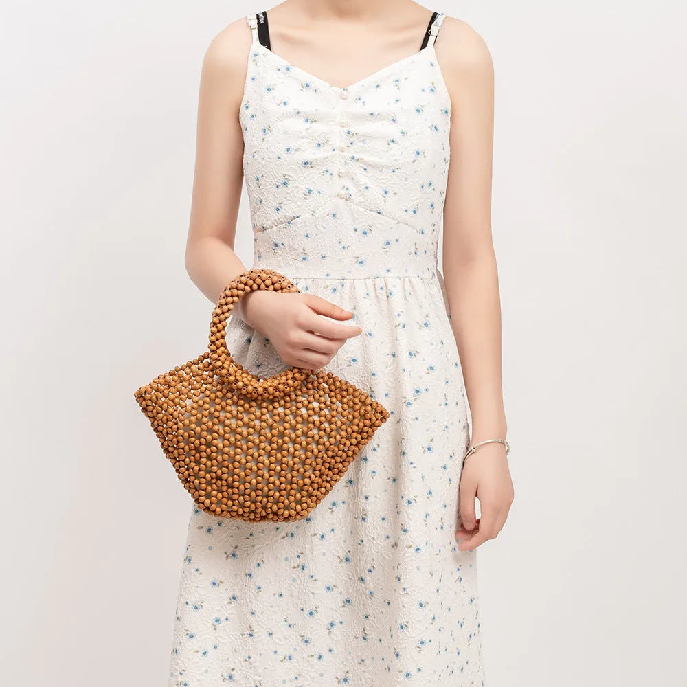 Maple wood woven dumpling-shaped handbag with wooden bead decoration, shown in milky white.