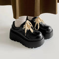 Matte black women's lace-up platform shoes with thick rubber sole and retro block heel.