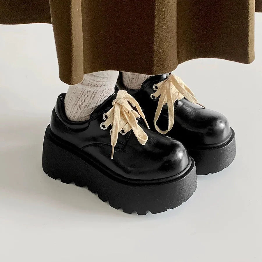 Matte black women's lace-up platform shoes with thick rubber sole and retro block heel.