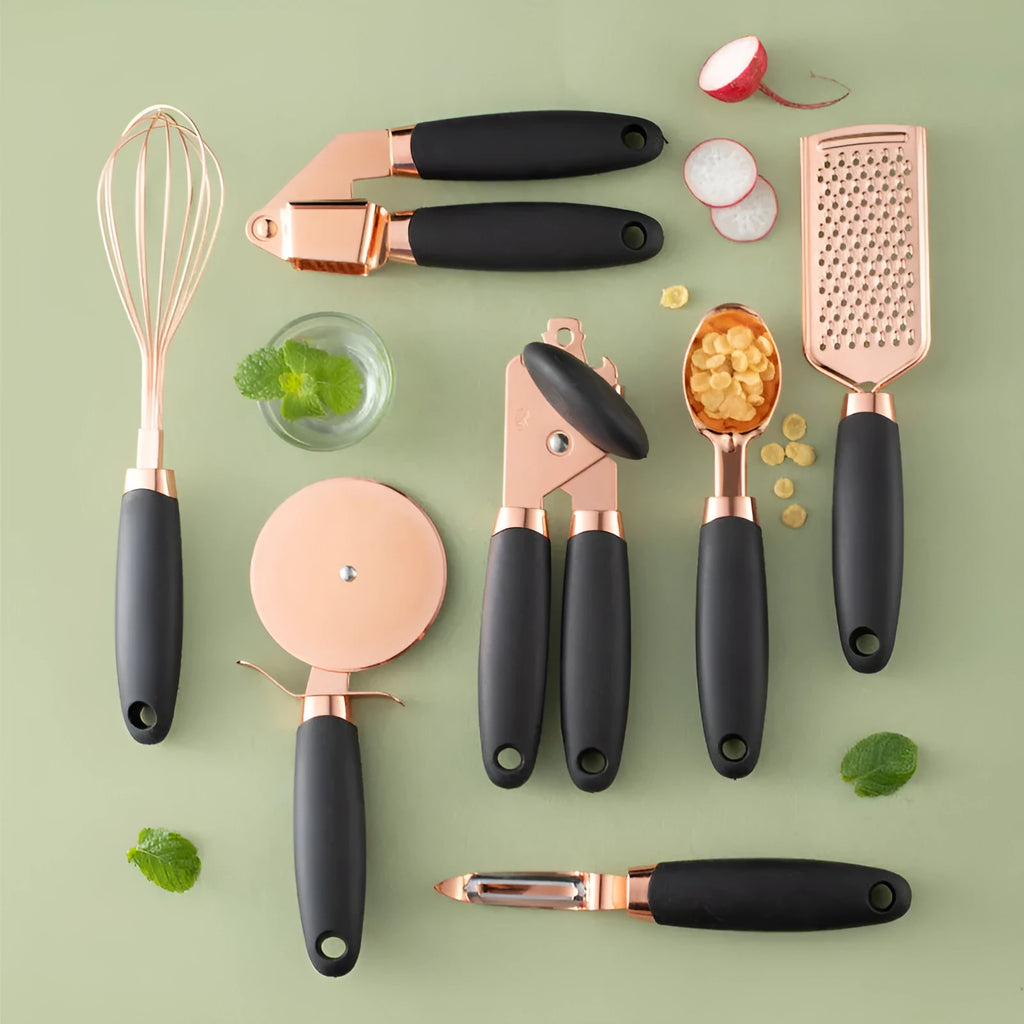 7-piece stainless steel kitchen tool set with copper plating in assorted colours on a countertop.