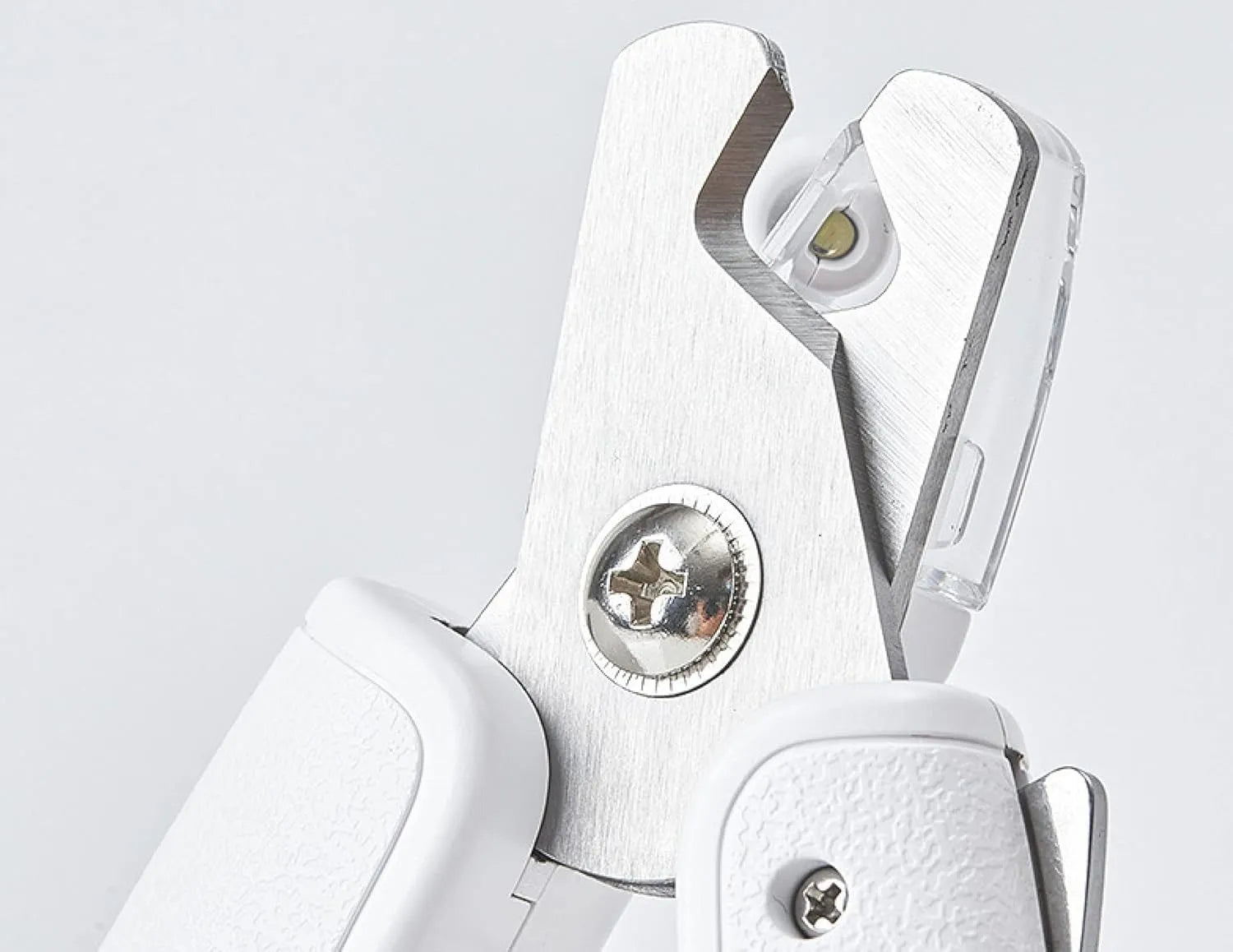 White pet nail clippers with LED light, transparent guard, and nail file on a grey background.