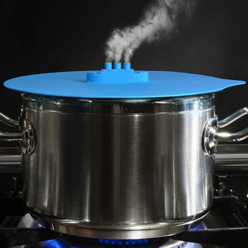 A silicone cooking lid with a ship-inspired design, featuring a three-port steam release system and a convenient hook for easy storage.