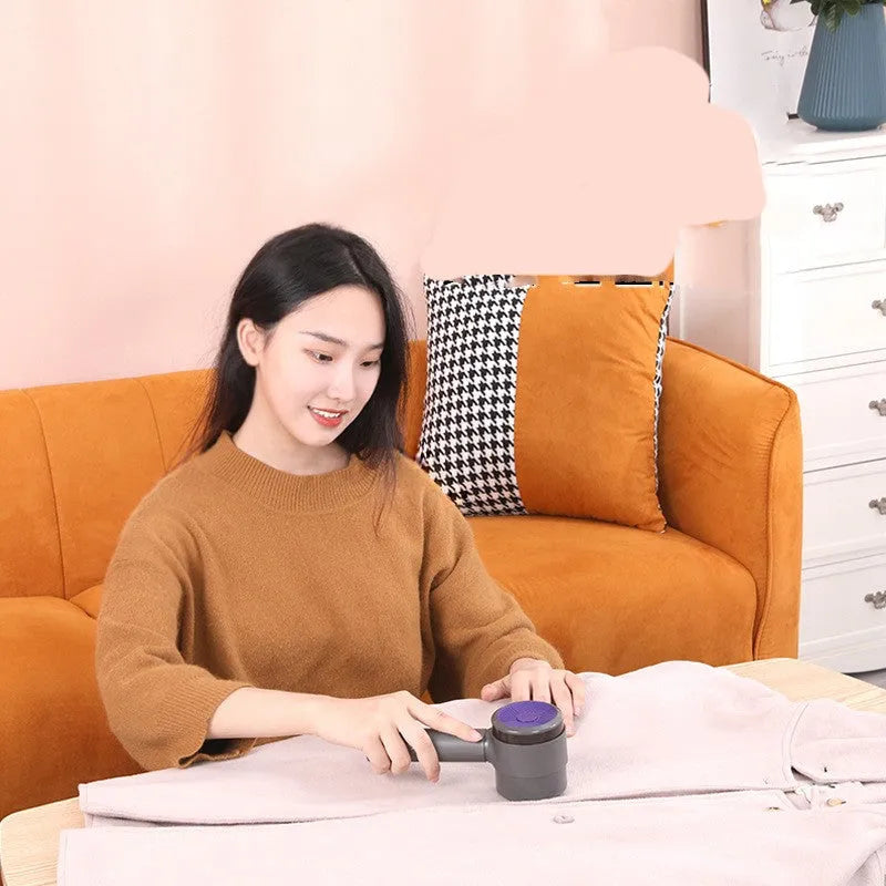 Blue purple electric hairball trimmer with suction and USB charging on a sweater