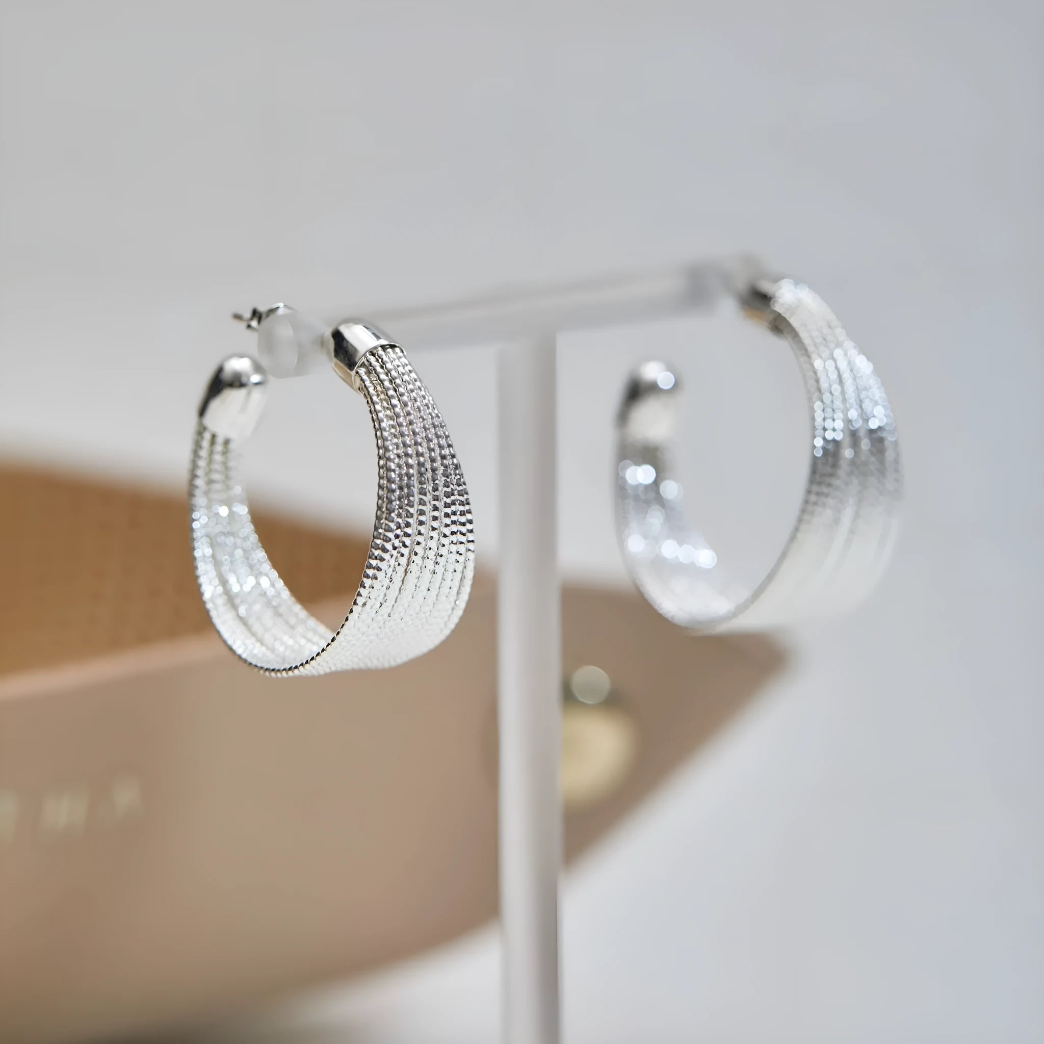 Set of four geometric earring pairs in silver and gold, including stud and clip styles