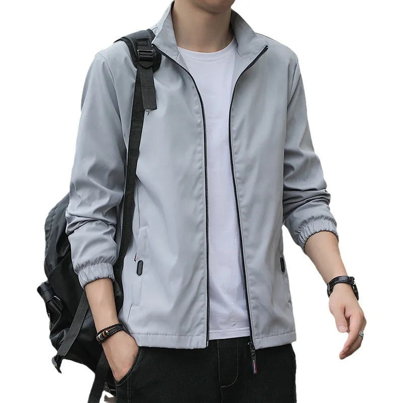 Man wearing a loose-fit black lapel collar casual jacket, Korean style, with zippered pockets.