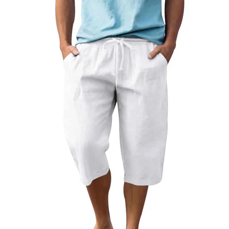 Man wearing loose, cropped linen shorts in a solid colour with a drawstring waist.