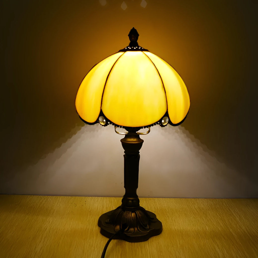 Modern minimalist beige coloured bedside lamp with a width of 20cm on a table.