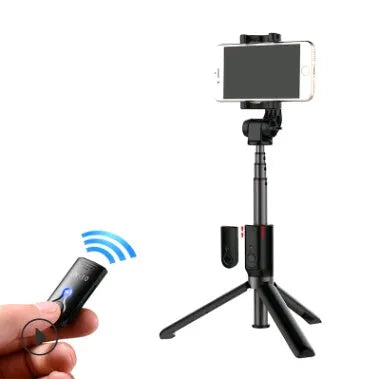 Aluminium telescopic Bluetooth selfie stick with tripod base and remote control next to a smartphone.