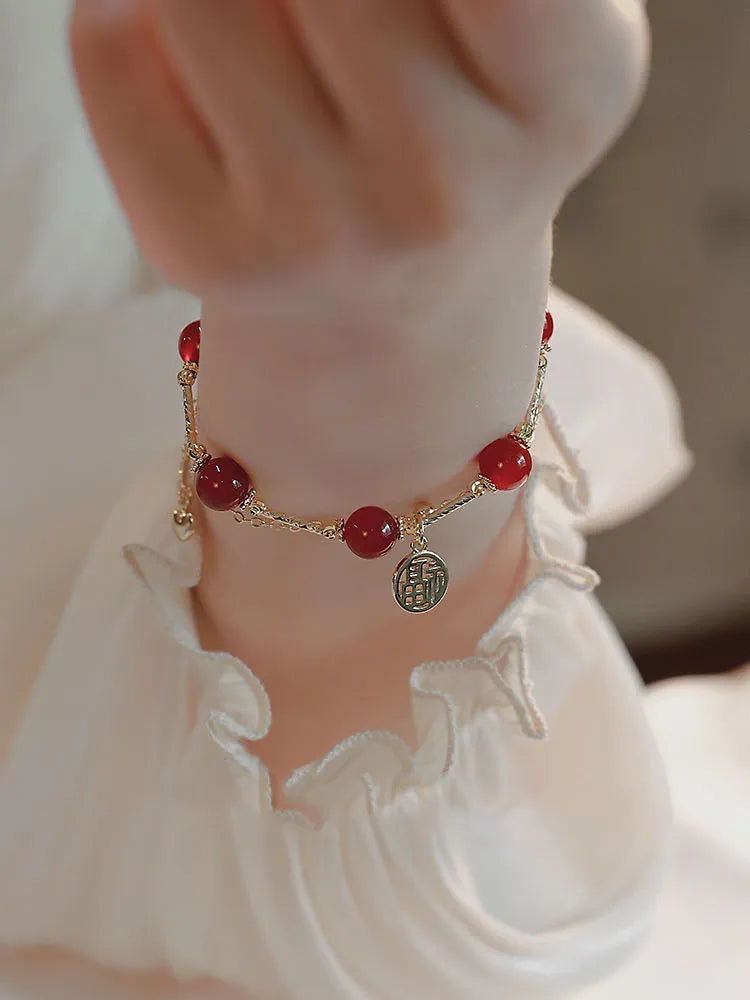 Red agate and alloy double-layer women's bracelet with a Red Horse blessing card charm on a white background.