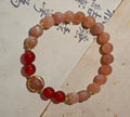 Handmade women's bracelet with 8mm red agate and sunstone beads in ethnic XINGX design featuring star and xiangyun elements