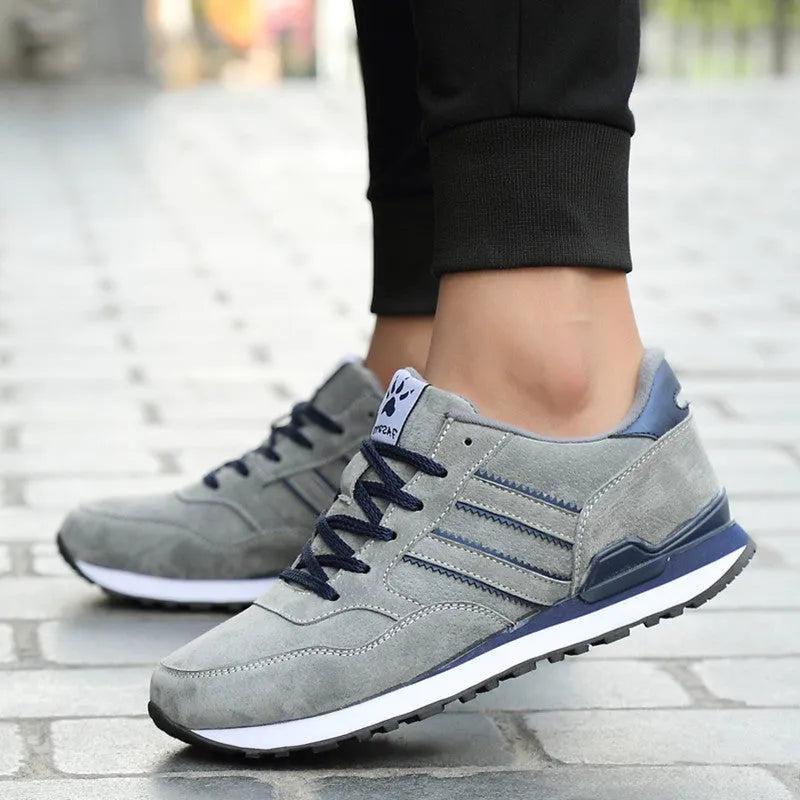 Men's blue pigskin leather sneakers with flat heel and rubber sole on grey background